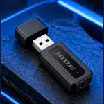 نمای نزدیک دانگل بلوتوث Earldom ET-M22 با بدنه مشکی، کانکتور USB-A و درگاه صدای 3.5 میلی‌متری روی پس‌زمینه آبی و مشکی
